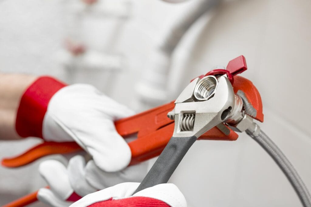 Plumber holding pipe wrenches for an emergency repair in Commerce City