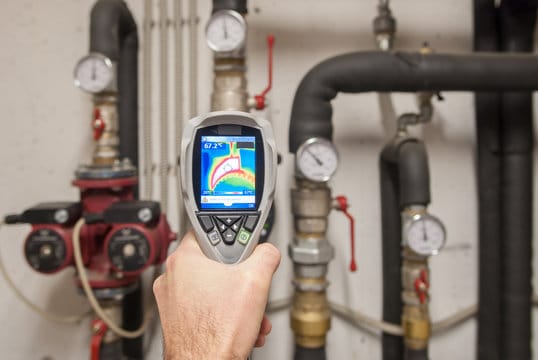 Plumber using a thermal imaging camera to inspect pipes in Commerce City