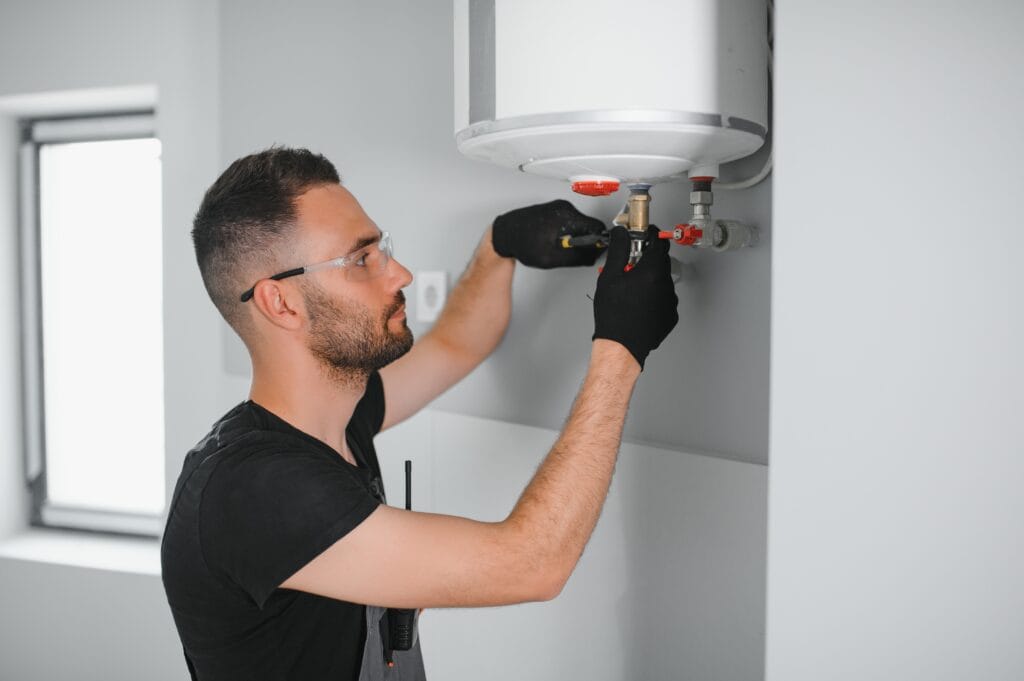 Technician performing water heater maintenance in Commerce City